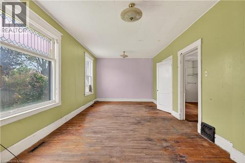 Spacious room featuring wood-finish flooring, white trim, and a window with a stained-glass upper pane - 26 Arthur Avenue, St. Thomas, ON - Indoor Photo Showing Other Room