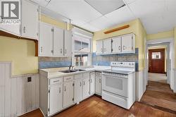 Kitchen featuring wood-finish flooring and white cabinetry - 