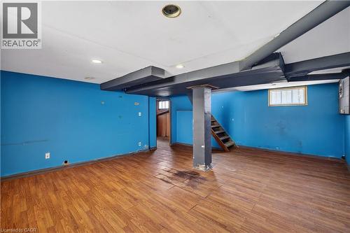 Spacious room with wood-finish flooring, recessed ceiling lighting, a window, and exposed structural beams - 26 Arthur Avenue, St. Thomas, ON - Indoor