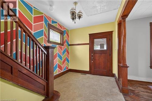 Entryway featuring rich wood-toned staircase and trim, a leaded glass window, and a paneled front door with a glass insert - 26 Arthur Avenue, St. Thomas, ON - Indoor Photo Showing Other Room