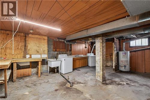 Utility space featuring a laundry area with washer connection, a utility sink, and wood-finish paneling - 26 Arthur Avenue, St. Thomas, ON - Indoor Photo Showing Basement