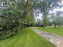 Expansive green lawn with a long, unpaved driveway - 165 E Ridge Road E, Grimsby, ON 