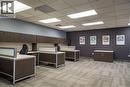 Open-plan office area featuring modular workstations with privacy panels, wood-finish cabinetry, and suspended acoustic ceiling tiles with integrated lighting - 5100 South Service Road, Burlington, ON 