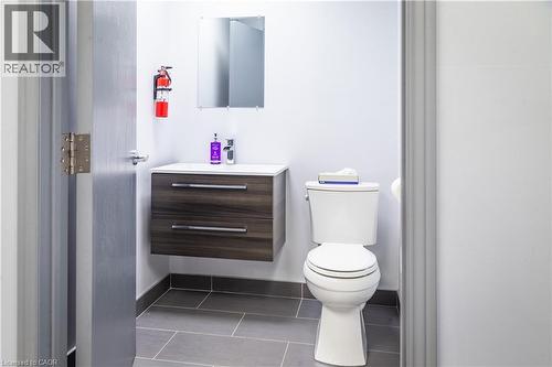 Modern bathroom vanity with wood-finish drawers, integrated white sink, and chrome faucet - 5100 South Service Road, Burlington, ON 