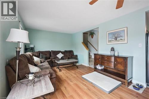 Spacious living area featuring wood-finish flooring, light blue wall paint, and a ceiling fan - 817 Acadia Drive, Hamilton, ON - Indoor Photo Showing Living Room