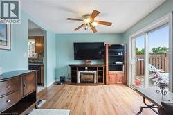 Dining area featuring wood-finish flooring, a built-in electric fireplace, and a ceiling fan - 
