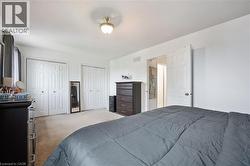Carpeted room featuring two sets of bi-fold closet doors, a white paneled interior door, and a ceiling-mounted light fixture - 