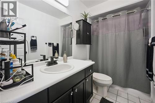 Bathroom featuring a black vanity with a white countertop, an undermount sink, and a matte black faucet - 817 Acadia Drive, Hamilton, ON - Indoor Photo Showing Bathroom