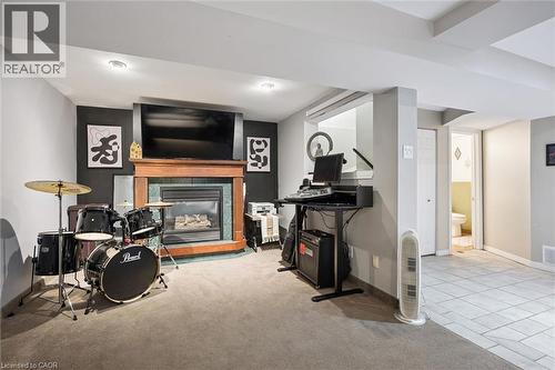 Finished basement with a wood-finish mantel and integrated fireplace - 817 Acadia Drive, Hamilton, ON - Indoor With Fireplace