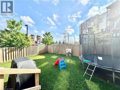 Fenced backyard with established lawn and mature perimeter trees - 1333 Countrystone Drive, Kitchener, ON 