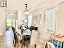 Dining area featuring a decorative chandelier, white window blinds, and tile flooring - 1333 Countrystone Drive, Kitchener, ON 