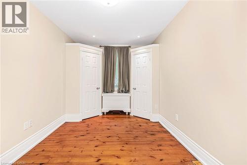 Room featuring rich wood-finish flooring, light-toned wall paint, and crisp white trim - 18 Pearl Street S, Hamilton, ON 