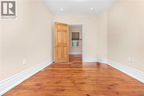 Room featuring wood-finish flooring, light-toned walls, recessed ceiling lighting, and white baseboards - 18 Pearl Street S, Hamilton, ON 