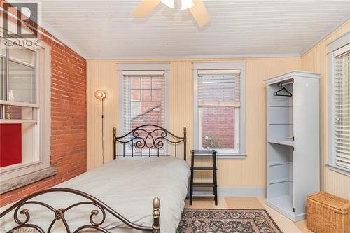 Exposed brick accent wall and light-colored paneled walls - 18 Pearl Street S, Hamilton, ON 