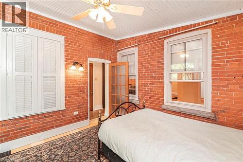 Exposed brick walls defining a room with wood-finish flooring - 18 Pearl Street S, Hamilton, ON 