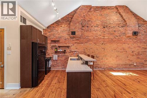Exposed brick feature wall with architectural details and track lighting - 18 Pearl Street S, Hamilton, ON 