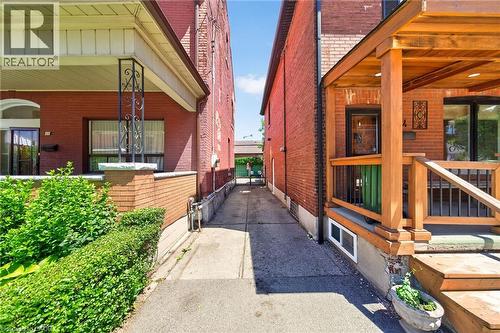 Concrete driveway with brick-clad exterior facades - 16 Mulberry Street, Hamilton, ON 