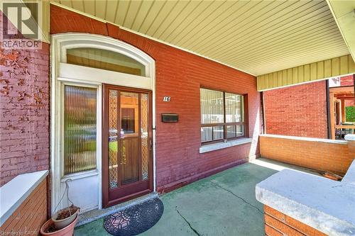 Covered front porch featuring a brick exterior and a white soffit ceiling - 16 Mulberry Street, Hamilton, ON 