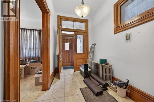 Entryway featuring light-toned tile flooring and a wood-paneled door with decorative glass inserts - 16 Mulberry Street, Hamilton, ON 