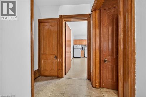 Hallway featuring light-toned square tile flooring and white walls - 16 Mulberry Street, Hamilton, ON 