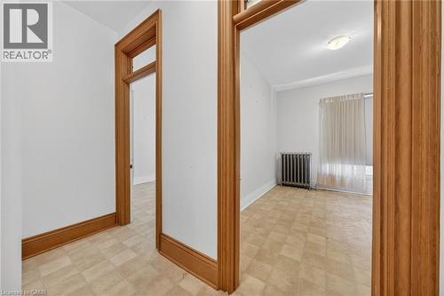 Interior entryway featuring wood-finish door frames and baseboards - 16 Mulberry Street, Hamilton, ON 