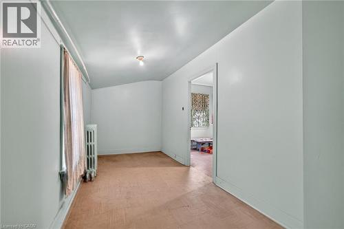 Room with light-colored walls, ceiling-mounted light fixture, and a window with vertical blinds - 16 Mulberry Street, Hamilton, ON 