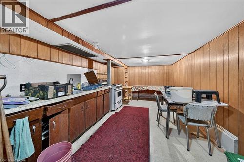 Lower-level room with extensive wood paneling, a white ceiling, and built-in shelving - 16 Mulberry Street, Hamilton, ON 
