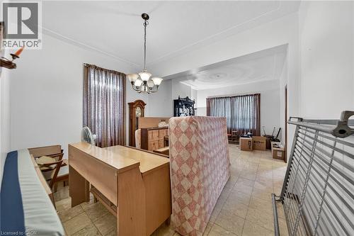 Room featuring neutral tile flooring, white walls, and a multi-light chandelier - 16 Mulberry Street, Hamilton, ON 