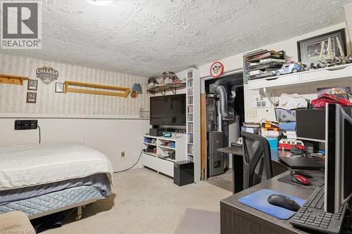 Carpeted room featuring a white paneled wall, striped wallpaper, and a popcorn ceiling - 116 Scott Road, Cambridge, ON 