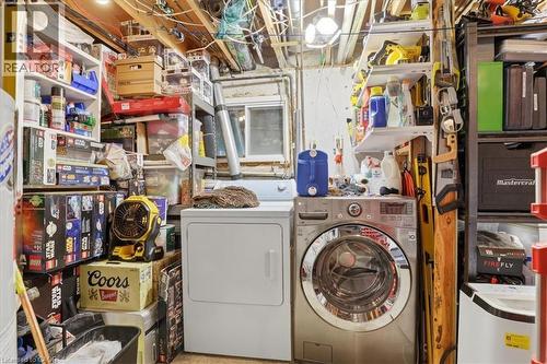 Laundry area featuring a front-loading washing machine, a white dryer, and exposed ceiling joists - 116 Scott Road, Cambridge, ON 