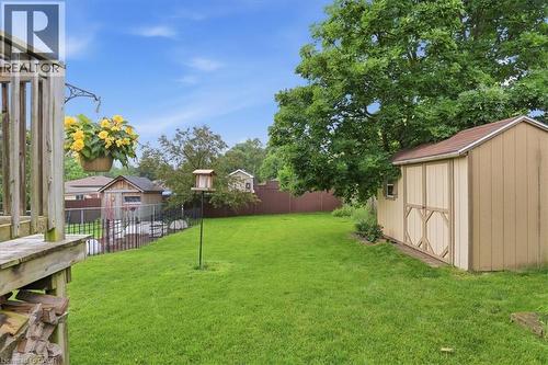 Expansive backyard featuring a manicured lawn, established shade tree, and a storage shed with a shingled roof - 116 Scott Road, Cambridge, ON 
