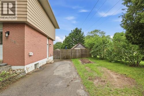 Brick exterior with tan siding and a paved driveway - 116 Scott Road, Cambridge, ON 