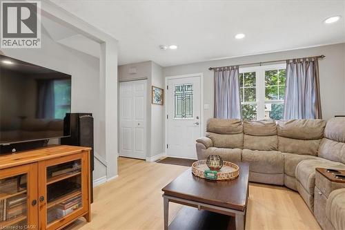 Living area featuring wood-finish flooring, recessed lighting, and a front entry door with decorative glass - 116 Scott Road, Cambridge, ON 