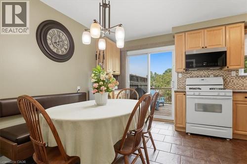 Eat-in kitchen featuring light wood cabinetry, a tiled backsplash, and durable tile flooring - 116 Scott Road, Cambridge, ON 