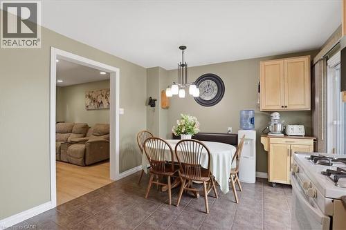 Dining area featuring a contemporary chandelier, built-in banquette seating, and tiled flooring - 116 Scott Road, Cambridge, ON 