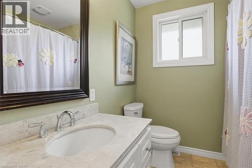 Bathroom featuring a vanity with an integrated sink, polished chrome faucet, and a light-toned countertop - 116 Scott Road, Cambridge, ON 
