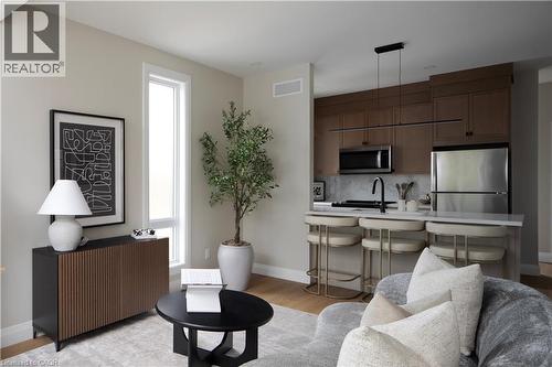 Open-concept living space featuring wood-finish flooring, a kitchen island with seating, stainless steel appliances, and sleek wood cabinetry - 210 Heritage Drive Unit# Upper, Kitchener, ON 
