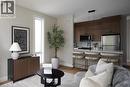 Open-concept living space featuring wood-finish flooring, a kitchen island with seating, stainless steel appliances, and sleek wood cabinetry - 210 Heritage Drive Unit# Upper, Kitchener, ON 