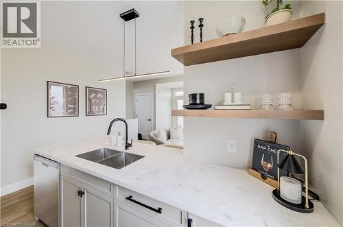 Kitchen island featuring a dual basin stainless steel sink, quartz-finish countertop, and matte black gooseneck faucet - 210 Heritage Drive Unit# Upper, Kitchener, ON 