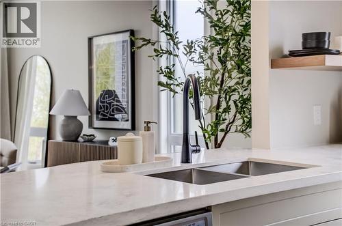 Contemporary kitchen island featuring a light-toned countertop, dual stainless steel sinks, and a matte black gooseneck faucet - 210 Heritage Drive Unit# Upper, Kitchener, ON 