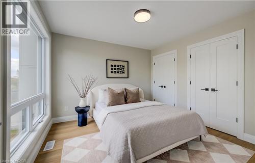 Light-filled interior featuring expansive windows, wood-finish flooring, two panel doors with matte black hardware, and a modern flush-mount ceiling light - 210 Heritage Drive Unit# Upper, Kitchener, ON 
