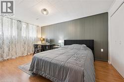 Room featuring wood-finish flooring, a paneled accent wall, and a built-in closet with bifold doors - 
