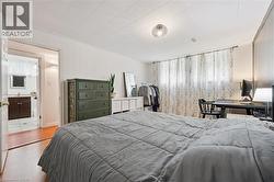 Spacious room featuring paneled walls, wood-finish flooring, and a ceiling light fixture - 