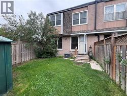 Private backyard featuring a manicured lawn, full privacy fencing, and a mature tree - 
