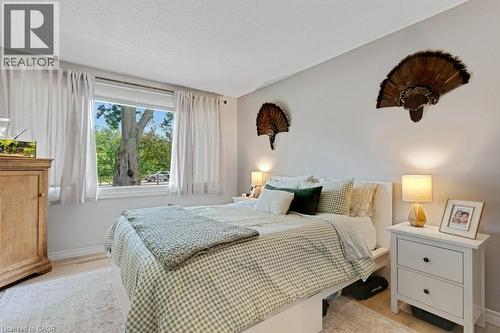 Apartment Inviting bedroom featuring light-toned walls, wood-finish flooring, and a large window with sheers - 3786 Old Beverly Road, North Dumfries, ON 