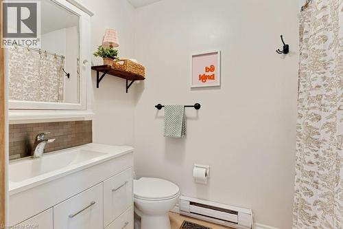 Apartment Bathroom featuring a white vanity with integrated sink, chrome faucet, and rectangular tile backsplash - 3786 Old Beverly Road, North Dumfries, ON 