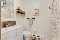 Apartment Bathroom featuring a white vanity with integrated sink, chrome faucet, and rectangular tile backsplash - 