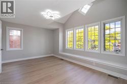 Room featuring wood-finish flooring, a vaulted ceiling, and multiple windows - 