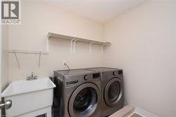 Utility room featuring a built-in wash tub, dual wall-mounted shelving, and a wire drying rack - 