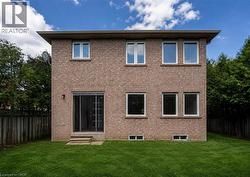 Brick exterior with a sliding glass door and concrete steps to a manicured lawn - 